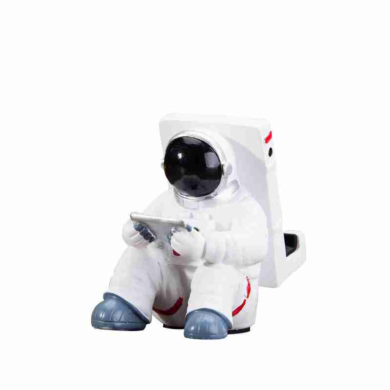 Astronaut Mobile Phone Stand Fun & Functional Desk Holder made of resin, featuring a seated astronaut figure holding a remote and supporting a smartphone.