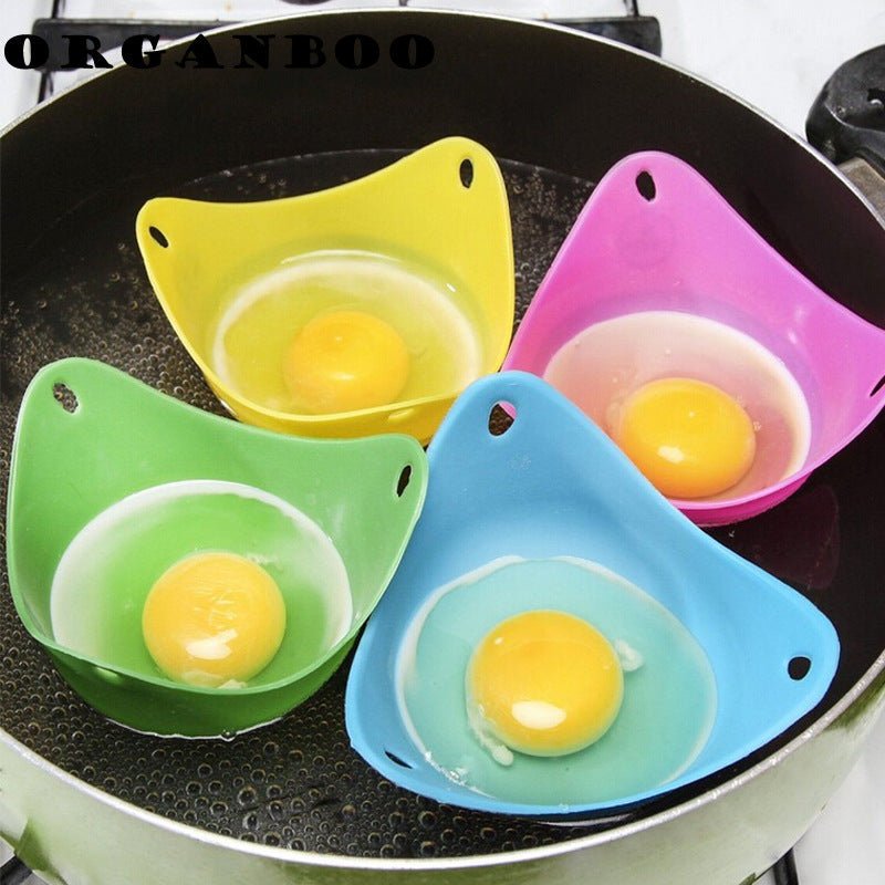 Green silicone egg cooker with yellow, pink, and blue silicone egg holders cooking eggs in a pan