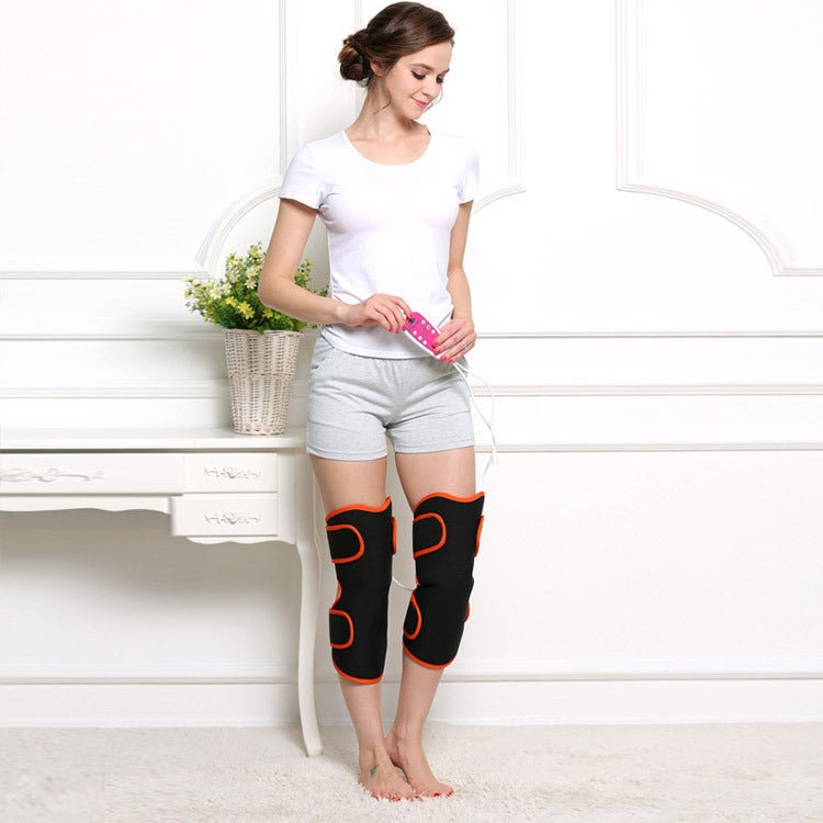 Warm heat electric heating knee protector leg vibration massager worn by woman sitting on floor. Multi-function joint massage device for legs.