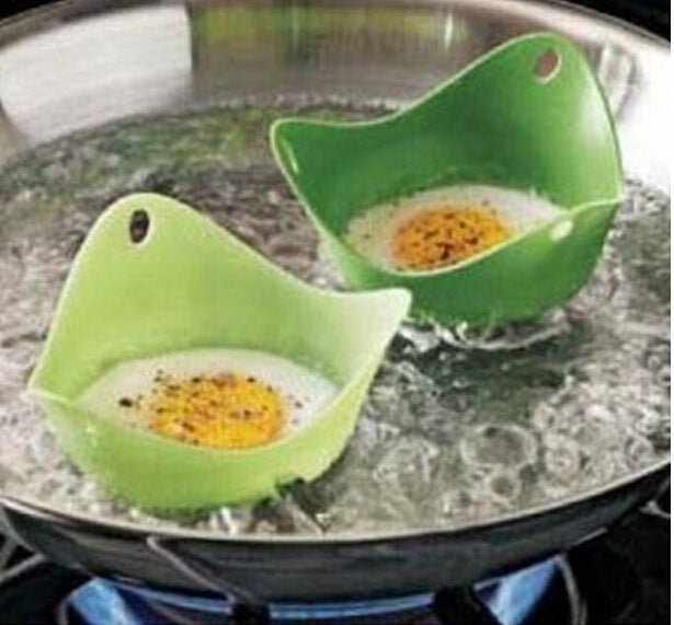 Green Silicone Egg Cooker 4 Color Silicone Egg Cooker set with eggs cooking in colorful silicone cups in a frying pan. Heat-resistant, non-stick kitchen tool.