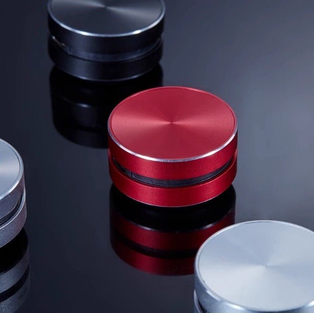 Compact bone conduction wireless Bluetooth speaker in red and black with magnetic design on reflective surface